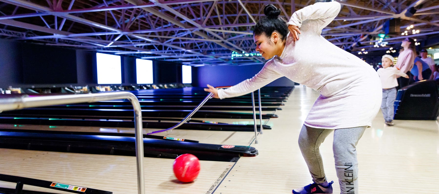 Young girl bowling a pink ball