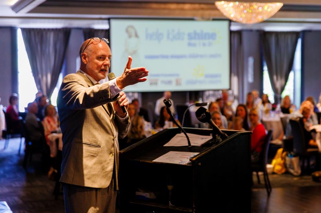 Presenter points towards audience in a banquet hall