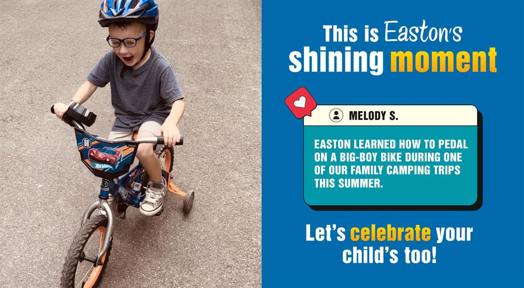 Child riding a bike with training wheels on a road